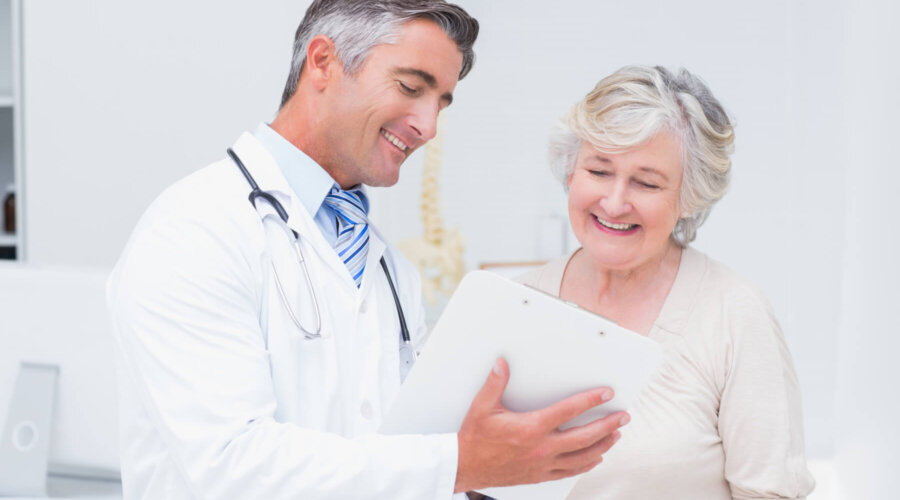 Happy doctor and patient discussing over reports in clinic